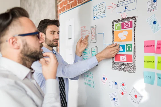 two men discussing marketing at whiteboard