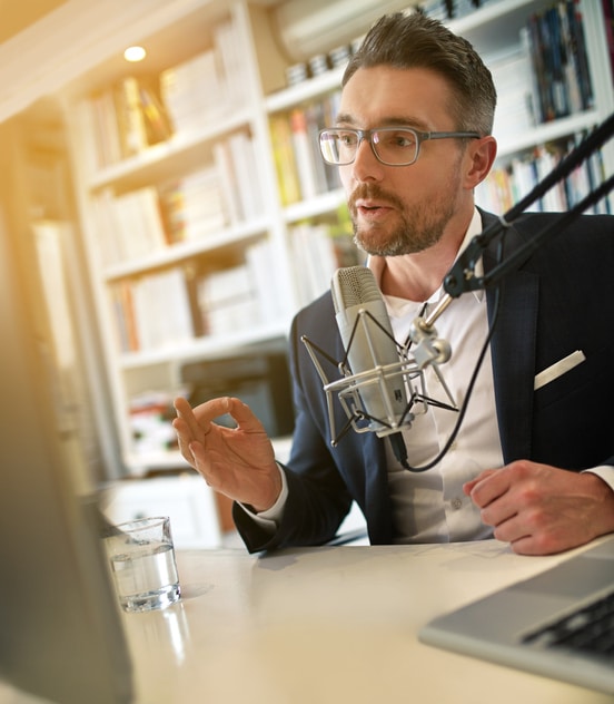Shot of a businessman making a podcast on his computer